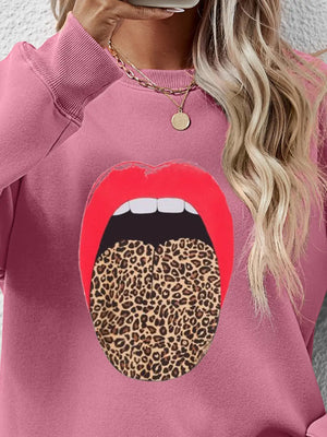 Pink sweatshirt with bold red lips graphic and leopard print tongue detail.