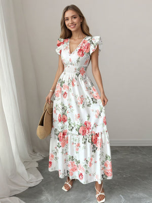 White floral maxi dress with ruffle sleeves, V-neck, and smocked waist.