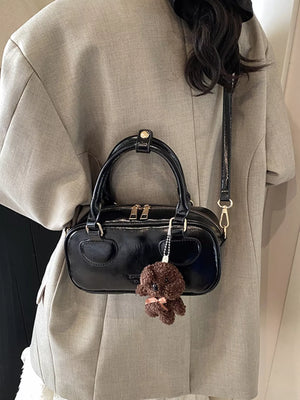 Black mini PU leather crossbody bag with top handles and a teddy bear charm