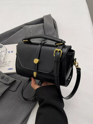 Black mini pu leather crossbody bag with gold clasp and adjustable strap.