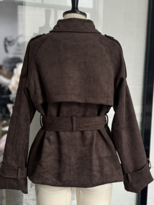 Brown lapel collar belted trench coat with tie waist and buttoned cuffs.
