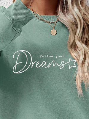 Sage oversized sweatshirt with white "follow your Dreams" graphic and star detail.