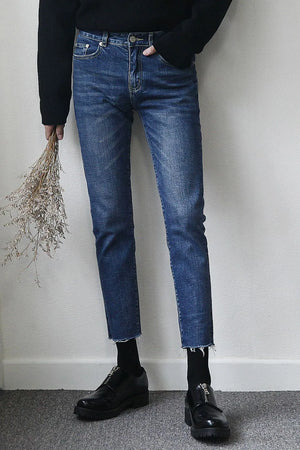 Slim-fit jeans in medium wash denim with raw hem detail