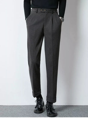 Men's dark gray tailored pleated dress pants with cuffed hems.