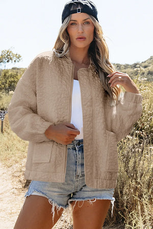 Dust Storm quilted bomber jacket with zip front and pockets, worn by a woman.
