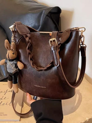 Brown braided bucket crossbody bag with bunny charm