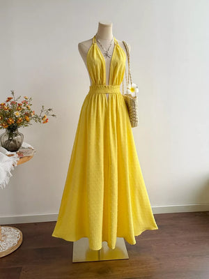 Yellow Swiss dot halter dress with a deep V-neck and a-line skirt.