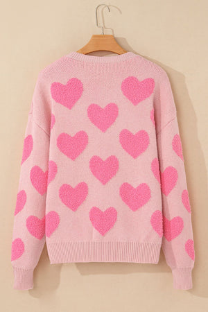 Blush pink knit sweater with allover textured bright pink heart motif.