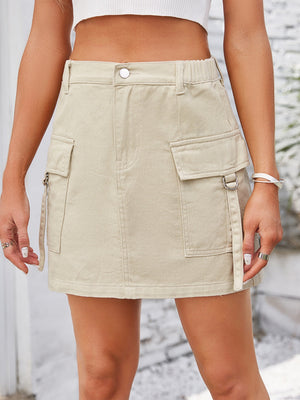 Tan denim A-line mini skirt with utility pockets and D-ring details