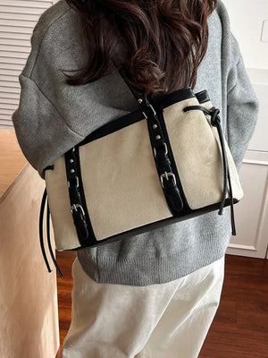 Two-tone suede tote bag with black leather trim and buckle details.