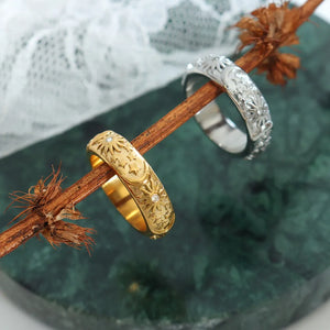 Gold and silver titanium bands with celestial engraving and small crystal accents.