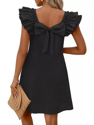 Black a-line dress with ruffled cap sleeves and a large bow detail at the back.