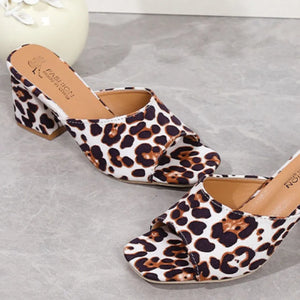 Leopard print block heel mules with open toe and white base.
