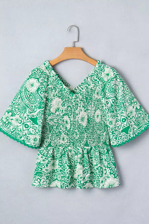 Green floral smocked v-neck polyester overshirt with ruffled sleeves.