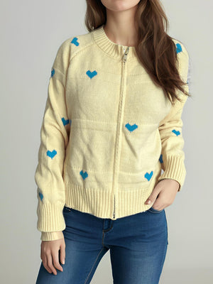 Pastel yellow zip-through knit cardigan with blue heart appliqué and ribbed cuffs.