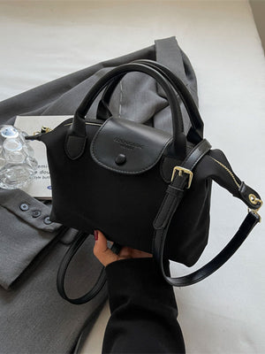 Black nylon crossbody bag with leather flap and top handles