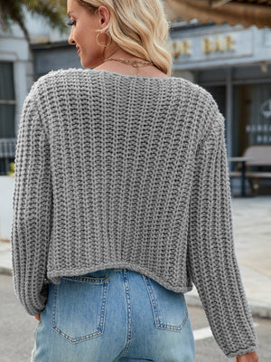 Gray chunky knit acrylic cardigan with gold buttons and pockets.