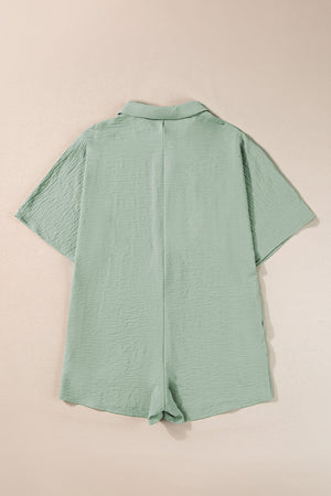 Sage oversized shirt romper with textured fabric and short sleeves.