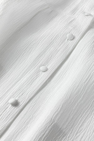 White crinkled texture button-down shirt with elastane, showing fabric detail and buttons.