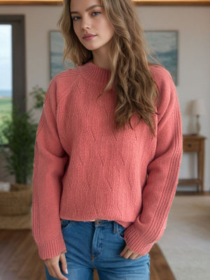 Textured knit raglan sleeve pullover in burnt coral with mock neck and diamond pattern.