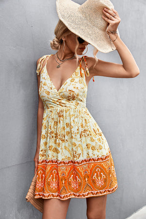 Bohemian print mini dress in light yellow with tie straps and orange border detail.