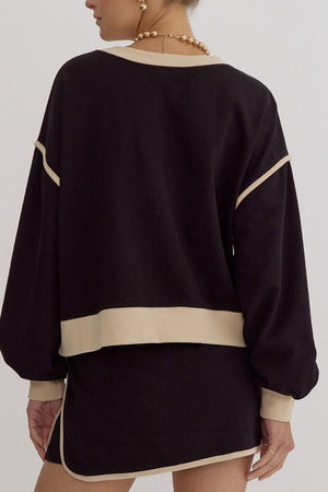 Black sweatshirt and skort set with contrast trim and beige neckline detail