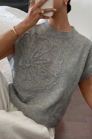 Gray knit top with embroidered bloom detail, crew neck, short sleeves.