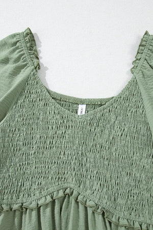 Sage smocked mini dress with V-neck, frill trim, and short sleeves.