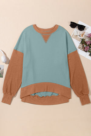 Chic contrast crewneck sweatshirt in turquoise and tan with V-stitch detail and hi-low hem.