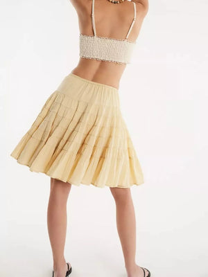 Tiered drawstring mini skirt in pastel yellow with subtle horizontal stitching detail.