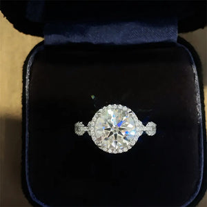 Halo moissanite engagement ring in silver with a twisted band and halo setting.