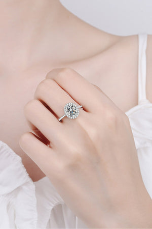 Silver pavé halo solitaire ring with oval center stone on a hand.