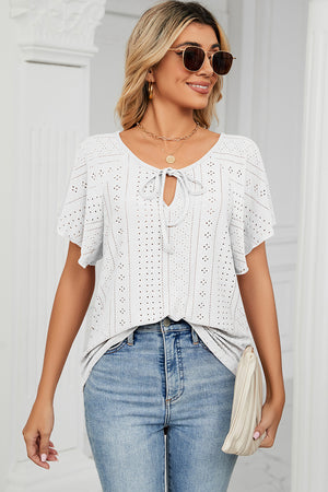 White eyelet tie-neck blouse with flutter sleeves and a keyhole cutout.