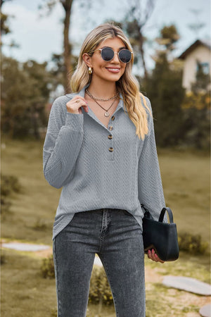 Light blue textured knit polo shirt with button detail and long sleeves.