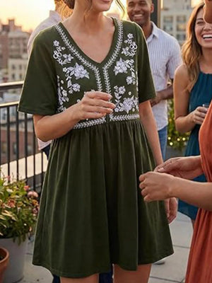 Army green cotton mini dress with white floral embroidery and V-neck.