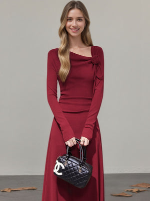 Burgundy ribbed maxi dress with asymmetrical neckline and floral detail.