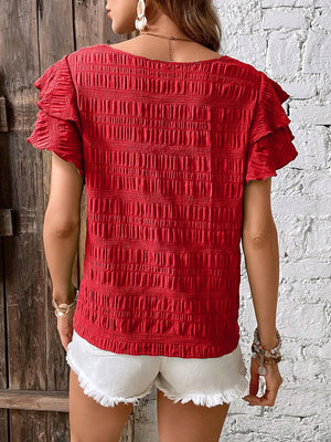 Red textured smocked blouse with ruffle sleeves.