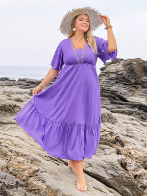 Purple V-neck tiered maxi dress with embroidered neckline and flutter sleeves.