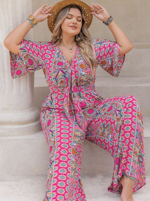Bohemian tie-front palazzo jumpsuit in pink with bell sleeves and a vibrant paisley print.