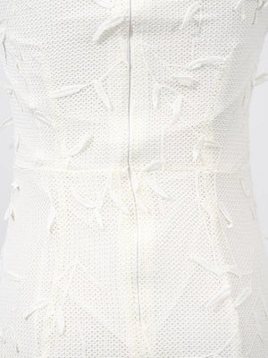 White midi dress with textured fabric and floral applique details.