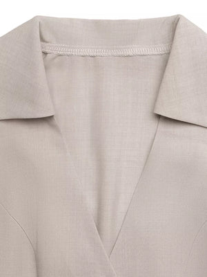 Beige collared midi dress with adjustable ties and button-down detail.