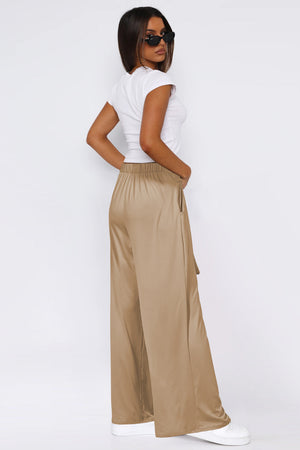 Tan palazzo trousers with tie waist and wide leg, styled with a white t-shirt.