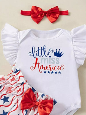 White baby onesie with "little miss America" graphic, ruffled sleeves, star print bloomer shorts, and red bow headband.