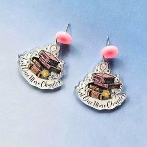 Book stack acrylic drop earrings in blush pink with "Just One More Chapter" text.