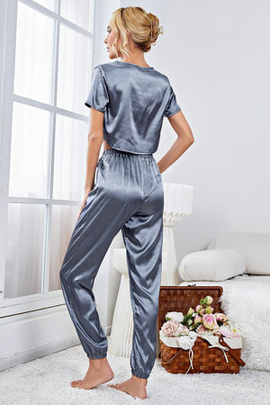 Steel satin crop top and jogger set with elastic cuffs, styled casually.