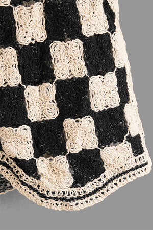Checkerboard crochet vest in black and cream with floral detail and button front.