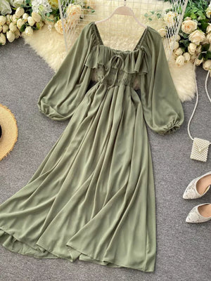 Green maternity dress with square neck, ruffled detail, tie front, smocked waist, and balloon sleeves.