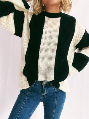 Black and cream vertical stripe waffle knit sweater with crewneck and long sleeves.