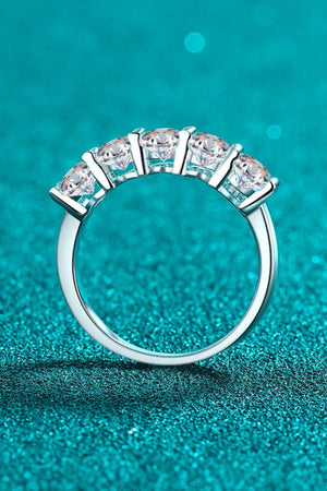 Silver band ring with five round moissanite stones in a celestial cluster setting.