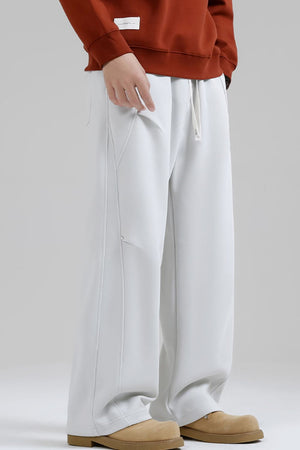 Men's white drawstring sweatpants with a relaxed fit and seam details.